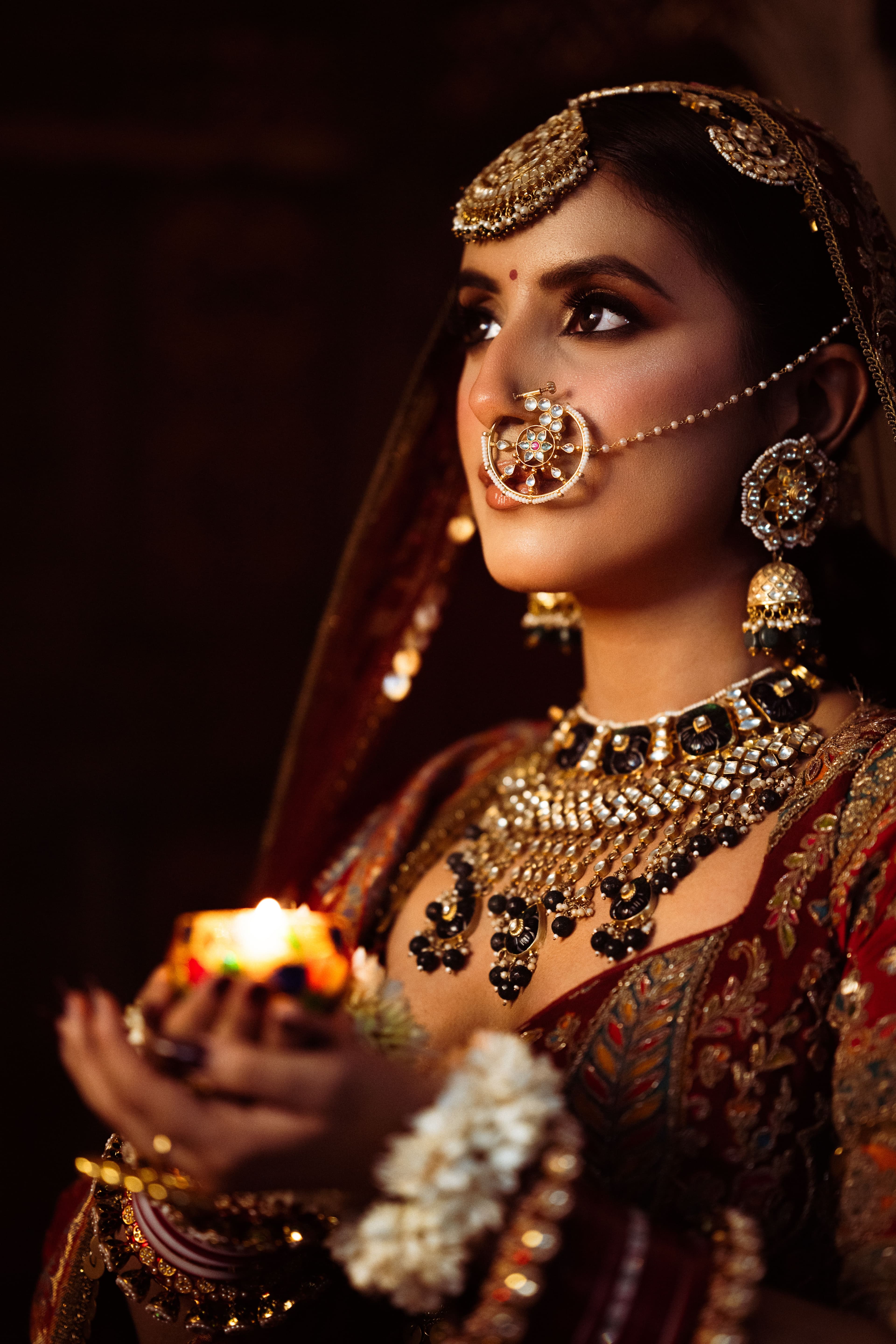 Bride holding a diya, wearing a kundan bridal set