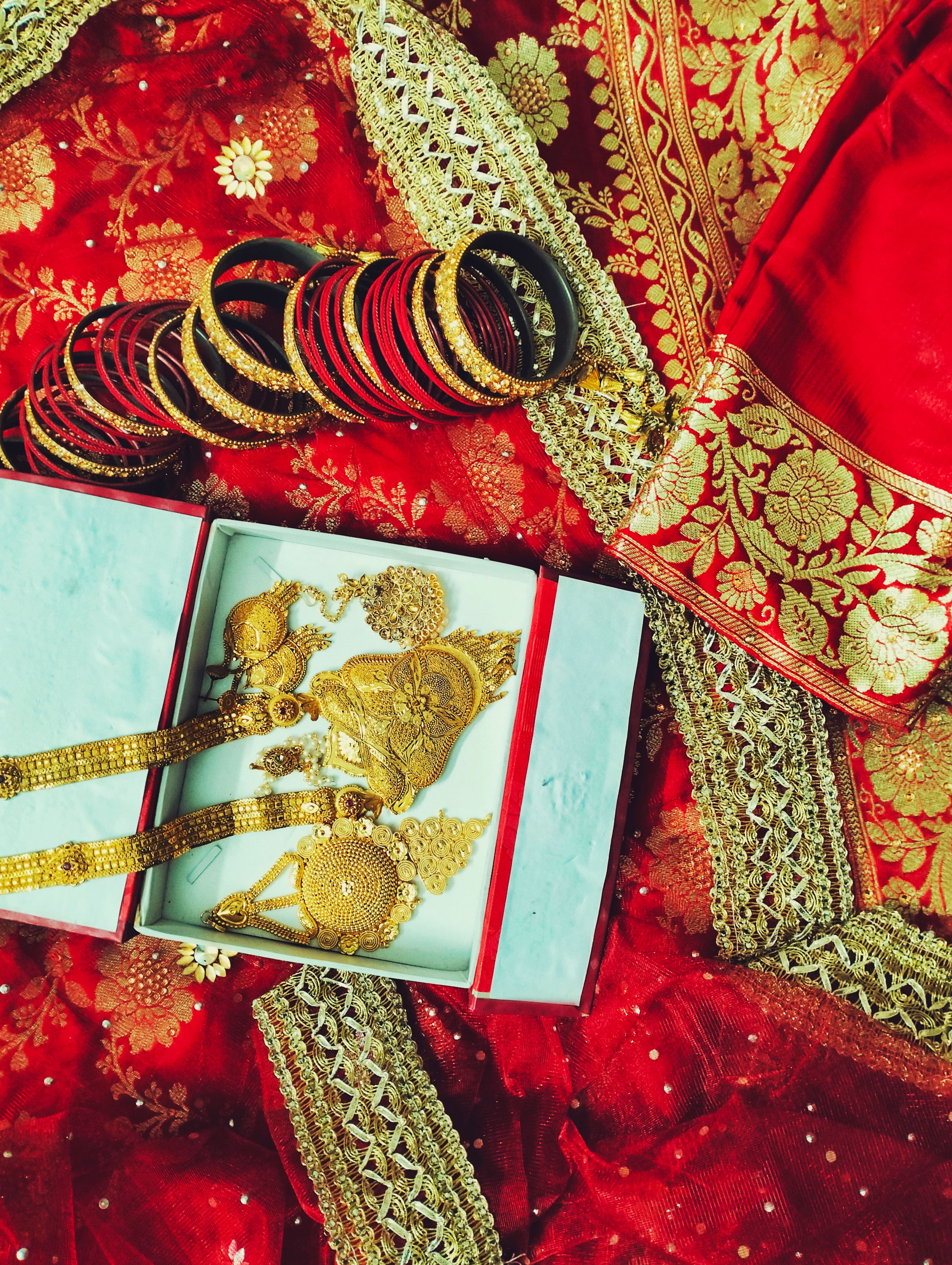 Bridal gold jewellery presented on maroon silk